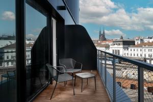 a balcony with two chairs and a view of a city at Clarion Congress Hotel Brno in Brno
