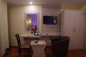 a room with a desk and a tv and a chair at Komal Hotel in Lālbhitti