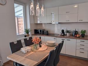 a kitchen with a wooden table with chairs and a dining room at Apartmany Rubin Nesvady in Nesvady
