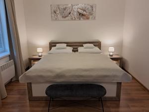 a bed in a bedroom with two lamps on two tables at Apartmany Rubin Nesvady in Nesvady