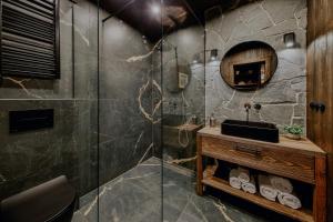 a bathroom with a shower with a sink and a mirror at Na Gorczańskim Wierchu Chalet, basen, sauna, balia na wyłączność in Rabka-Zdrój