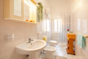 a white bathroom with a sink and a toilet at Piazza Verdi-Roseto Vacanza in Roseto degli Abruzzi