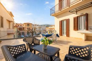 a patio with chairs and tables on a balcony at Piazza Verdi-Roseto Vacanza in Roseto degli Abruzzi +2 photos