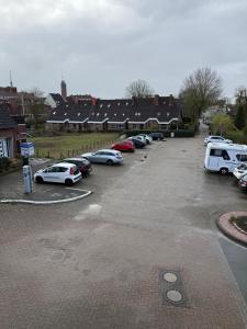 a parking lot with a bunch of cars parked at Van Kim 1 Ferienwohnung in Emden +2 photos