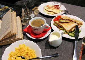 a table with plates of food and a cup of coffee at PEOPLE Loft Tverskaya Hotel in Moscow
