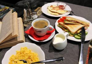 una mesa con platos de comida y una taza de café en PEOPLE Loft Tverskaya Hotel, en Moscú