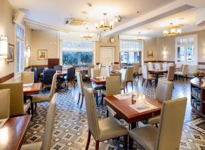 a dining room with wooden tables and chairs at The Colony Hotel in Haifa