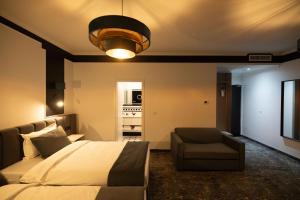 ein Schlafzimmer mit einem Bett, einer Couch und einer Lampe in der Unterkunft Opera Hotel in Timişoara