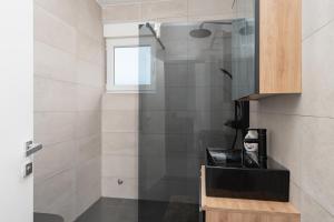a shower with a glass door in a bathroom at Premium Apartment Obatnice with Pool in Povljana