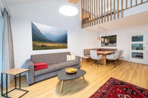 a living room with a couch and a table at Wiesenblick Residences - by myNests in Haus im Ennstal