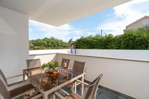 a balcony with a table and chairs on a building at Premium Apartment Obatnice with Pool in Povljana