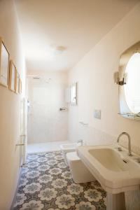 a white bathroom with two sinks and a tub at Wp Relais Mazzini in Montalcino