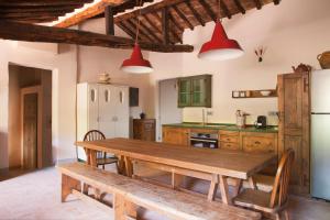 a kitchen with a wooden table and a refrigerator at Wp Relais Mazzini in Montalcino +55 photos