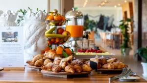 a buffet with croissants and other pastries and fruit at Eureka Palace Hotel Spa in Cassibile