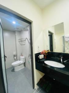 a bathroom with a sink and a toilet and a mirror at CHIRU House Ninh Bình in Ninh Binh