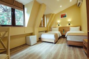 a bedroom with two beds and a window at Hotel Date in Tbilisi City
