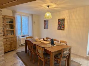 a dining room with a wooden table and chairs at Maison Saizy in Monceaux-le-Comte
