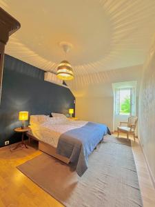 a bedroom with a large bed with a blue headboard at Maison Saizy in Monceaux-le-Comte
