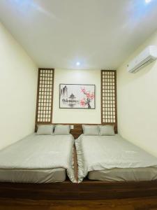 two twin beds in a room with a picture on the wall at CHIRU House Ninh Bình in Ninh Binh +5 photos