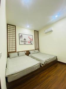 a room with two beds and a painting on the wall at CHIRU House Ninh Bình in Ninh Binh