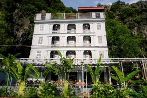 a white building with trees in front of it at The Hive Homestay - Tam Coc in Ninh Binh