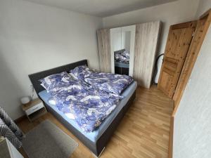 a bedroom with a bed with a blue comforter at Haus Cronenberg im Harz in Wernigerode