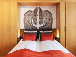 a bedroom with a large bed with red pillows at Scandic Stiklestad in Verdal +20 photos