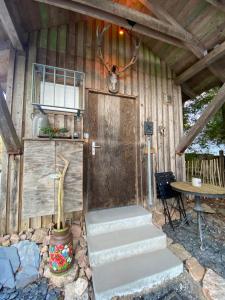 a cabin with a wooden door and some stairs at Wildhütte Schinderhannes in Schwarzerden