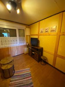 a living room with yellow walls and a television at Wildhütte Schinderhannes in Schwarzerden +6 photos
