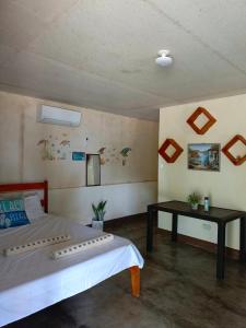 a bedroom with a bed and a table in it at Coastline Homestay in Burgos