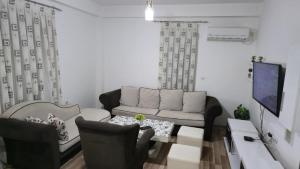 a living room with a couch and a tv at Ceca & Dimi Apartments 2 in Gevgelija