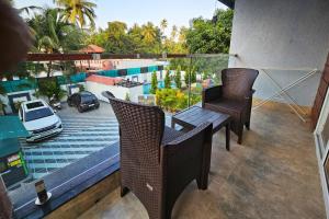 a balcony with a table and chairs and a view of a pool at Basil Leaf Resort in Varsoli