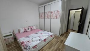 a small bedroom with a pink bed and a closet at Ceca & Dimi Apartments 2 in Gevgelija