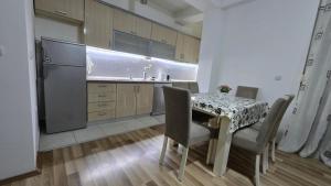 a kitchen with a table and chairs and a refrigerator at Ceca & Dimi Apartments 2 in Gevgelija