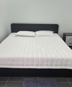 a bed with white sheets and pillows on it at Tú Nguyên Motel in Ban Beng