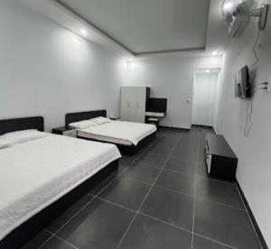 a room with two beds and a tv in it at Tú Nguyên Motel in Ban Beng