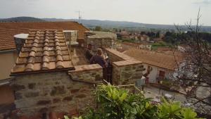 a woman standing on the balcony of a building at La Torre della Bella Ragazza in Suvereto