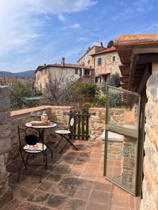 a patio with a table and chairs on a stone wall at La Torre della Bella Ragazza in Suvereto +17 photos