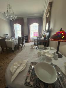 a dining room with a table with plates and utensils at Ashmore House Cashel in Cashel