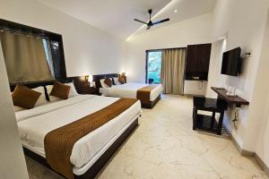 a hotel room with two beds and a desk at Basil Leaf Resort in Varsoli +58 photos
