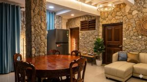 a kitchen and dining room with a table and a couch at Nur Nur Residence and villa in Surin Beach