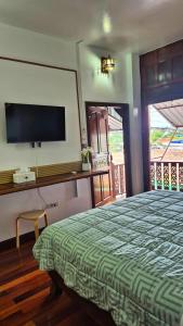 a bedroom with a bed and a tv on the wall at Nur Nur Residence and villa in Surin Beach +186 photos