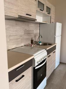 a kitchen with a stove and a white refrigerator at Apartamentai Jonavoje #1 in Jonava