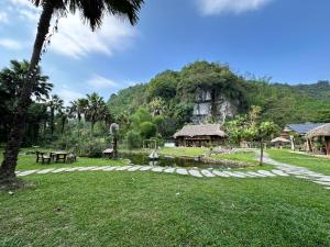a park with a stone path and a building in the background at Laben Ecolodge in Na Dong