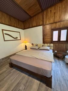 a bedroom with a large bed in a room with wooden walls at Laben Ecolodge in Na Dong