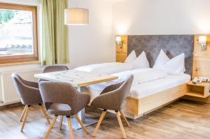 a bedroom with a bed and a table and chairs at Pension Edelweiß in Sankt Johann im Pongau