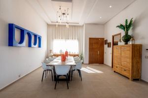 a dining room with a table and chairs at Villa Palms de l'Atlas in Marrakesh