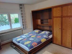 a bedroom with a bed and a wooden cabinet at Ferienwohnung Kroeschell in Bad Sachsa