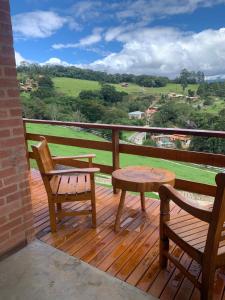 a wooden deck with a table and a chair and a table at chalés Roma in Santo Antônio do Pinhal