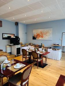 a dining room with tables and chairs and a kitchen at Hotel Sagitta in Geneva +27 photos